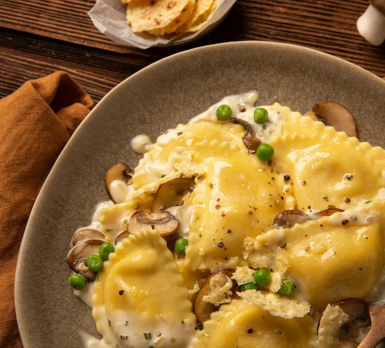 Herbstgenuss mit Mezzelune Carbonara, Erbsen, Champignons und Parmesan-Chips